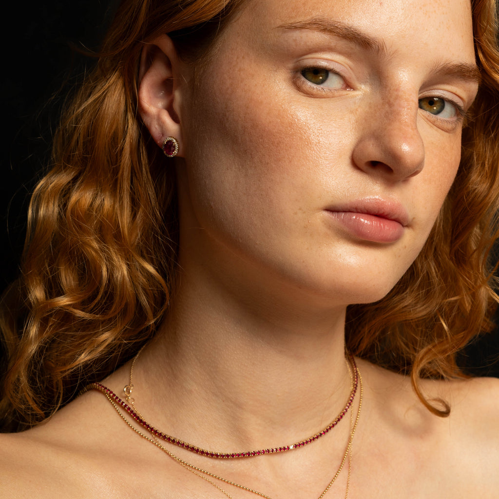 Woman with red hair and freckles against a black background